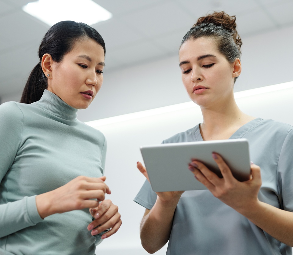 Two clinic staff reading information on a tablet together